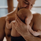 Cheerful father holding his cute newborn baby.