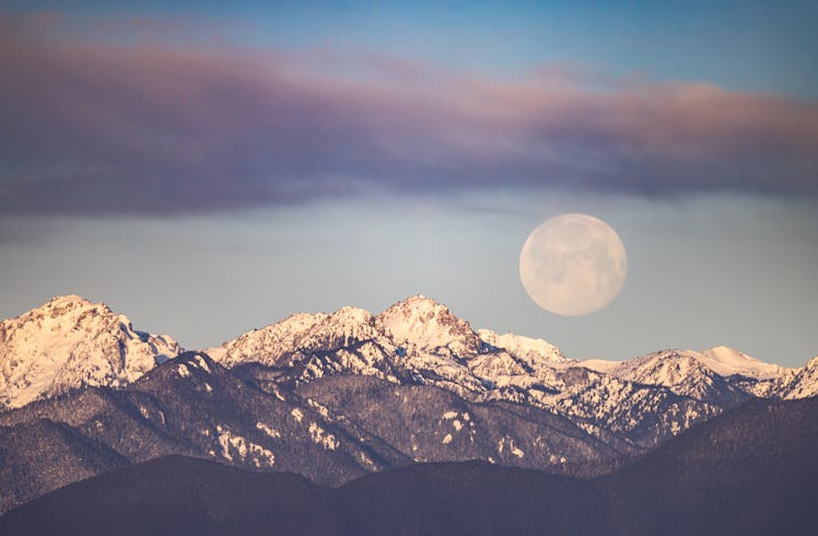 the february 2023 full snow moon sets above mountains, as fixed signs consider how they'll be most i...