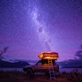 Starry night with backdrop of southern alps of New Zealand and beautiful Lake Ohau in South Island, ...