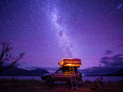 Starry night with backdrop of southern alps of New Zealand and beautiful Lake Ohau in South Island, ...