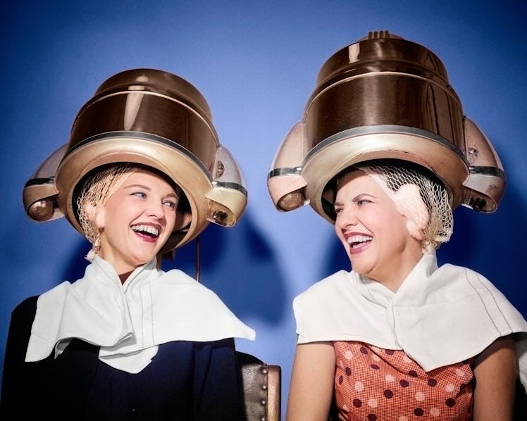 1950s Two Laughing Women Sitting Under Beauty Salon Hair Dryers Wearing Hair Nets Towels Talking Gos...