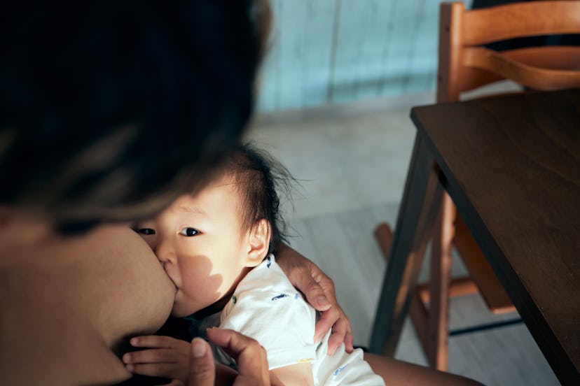 photo of asian baby nursing in article about drinking champagne while breastfeeding