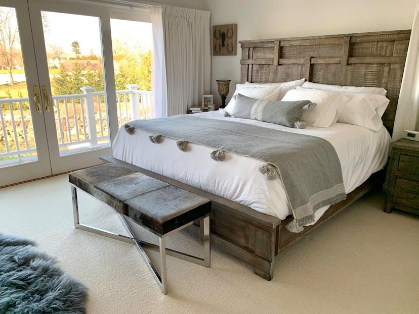 A modern, stylish bedroom complete with a king size wooden grey bed creates a restful space. White w...