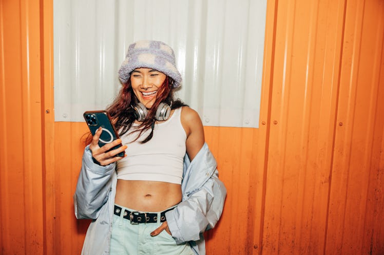 Woman texting outside a club, her zodiac sign's guilty pleasure.