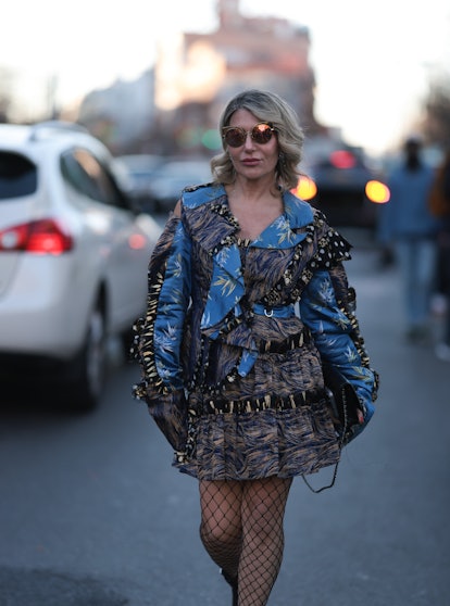 NEW YORK, NEW YORK - FEBRUARY 10: Olga Ferrara seen wearing a blue printed dress, black boots, fishn...