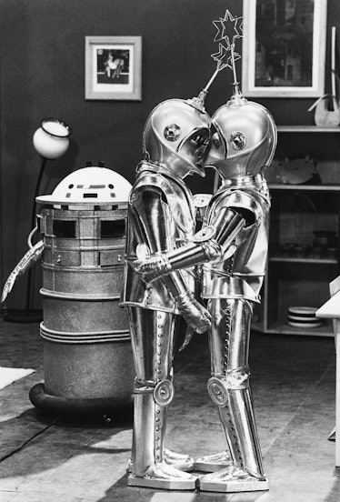 Two robots kiss during the filming of the movie Seven Golden Men Out to Conquer Space.
