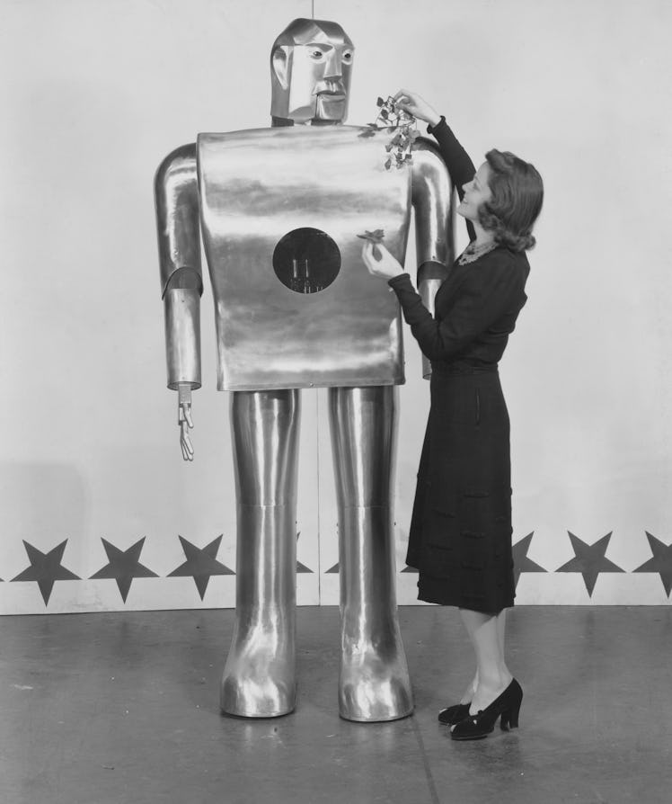 Musician Lois Kendall decorates mechanical man Elektro with leaves as part of a Westinghouse Electri...