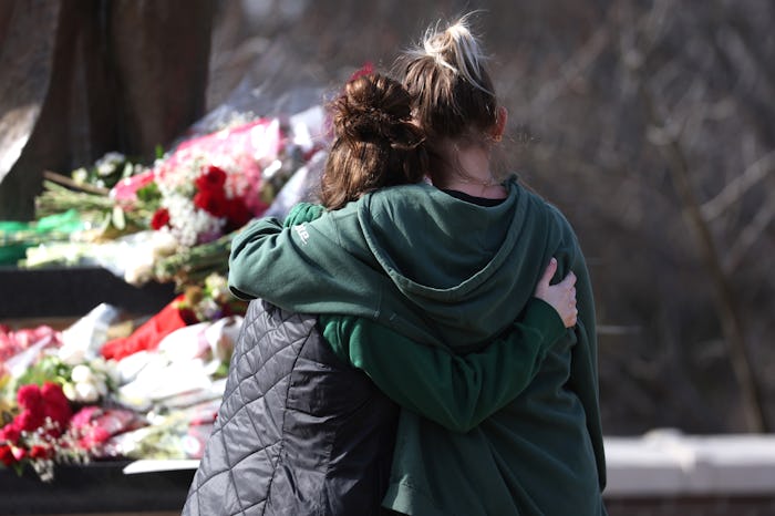 EAST LANSING, MICHIGAN - FEBRUARY 14: People leave flowers, mourn and pray at a makeshift memorial a...