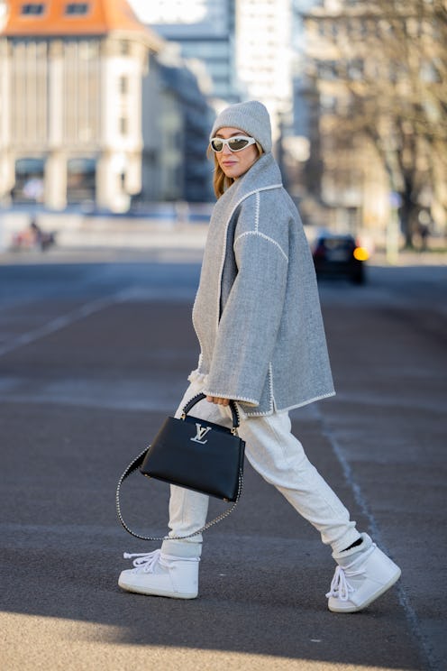 BERLIN, GERMANY - JANUARY 20: Sonia Lyson wears Inuikii ski boots, creme jogger suit Zara, bag Louis...