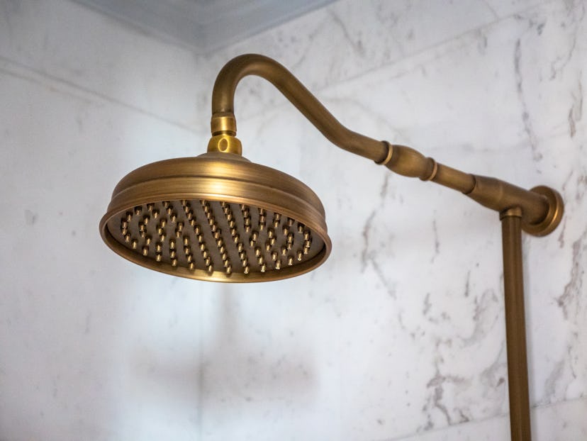 Spa Health and Wellness Concept - Brass Shower Head in a Treatment Room style setting for relaxing l...
