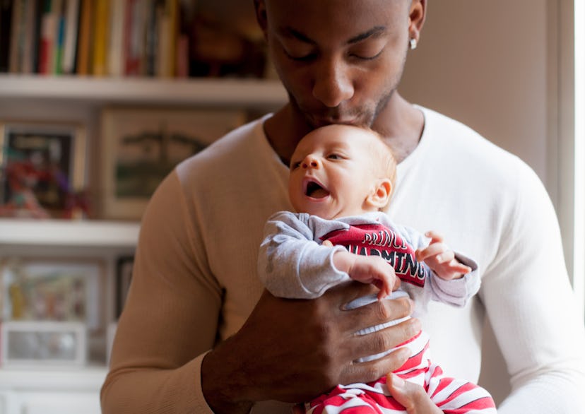 a father holding his baby in an article about the 4 month sleep regression, causes and how to surviv...