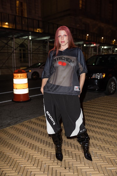 Julia Fox wears transparent see trough sports jersey, wide leg sports shorts, black varnished boots