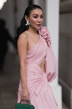 NEW YORK, NEW YORK - FEBRUARY 13: Jessica Wang seen wearing a pink dress with cutouts and a green ba...
