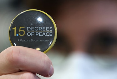 A button bearing the name of the documentary "1.5 Degrees of Peace" is pictured at the Sharm el-Shei...