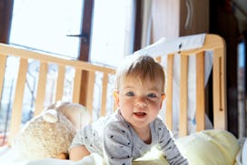 a baby that is wide awake in their crib, possibly because of a 12 month sleep regression