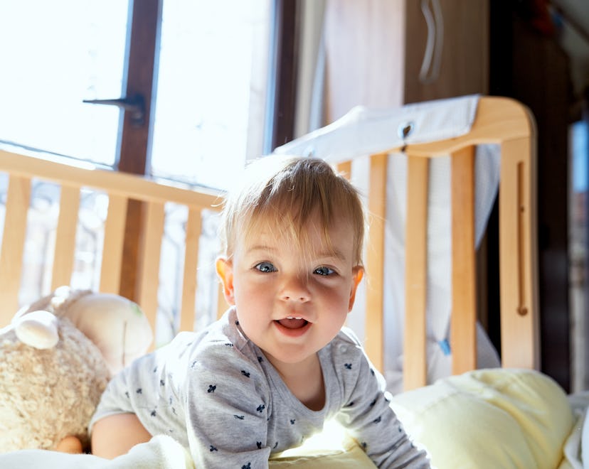a baby that is wide awake in their crib, possibly because of a 12 month sleep regression