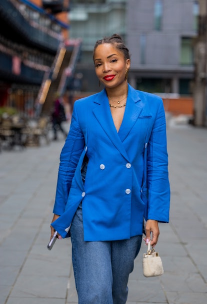 LONDON, ENGLAND - FEBRUARY 18: Ellie Delphine wears blue button up blazer, denim jeans, creme white ...