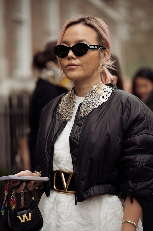 A guest wearing a white dress, black cropped jacket, Christian Dior sunglasses, and black mini bag o...