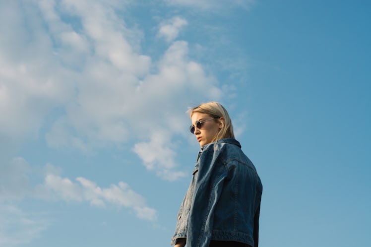 young woman poses against the sky with her back turned, as she considers her february 6, 2023 weekly...