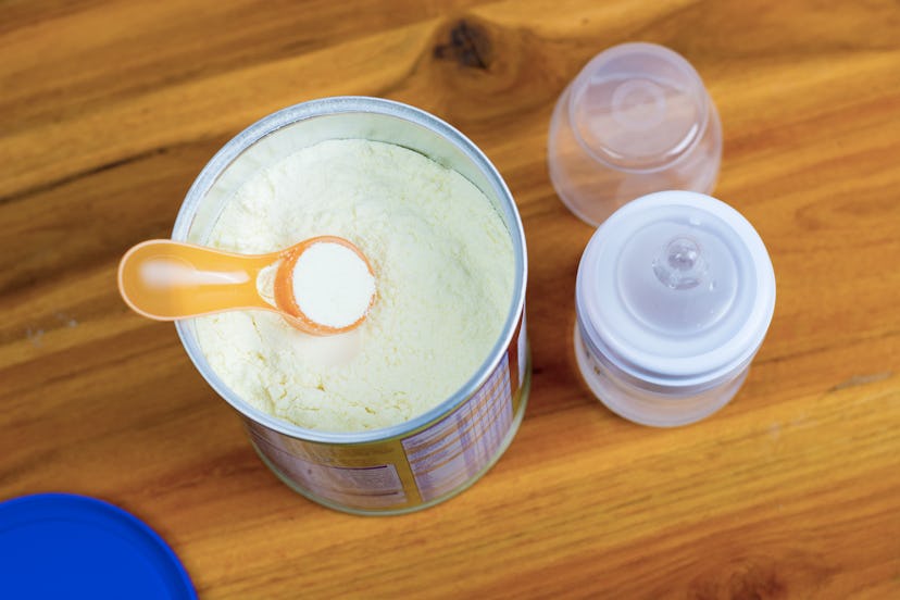 preparation of mixture baby feeding on wooden background.