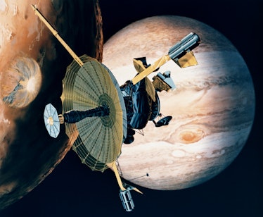 circa 1989:  NASA's Galileo probe passing over one of Jupiter's 16 moons. The planet's Great Red Spo...