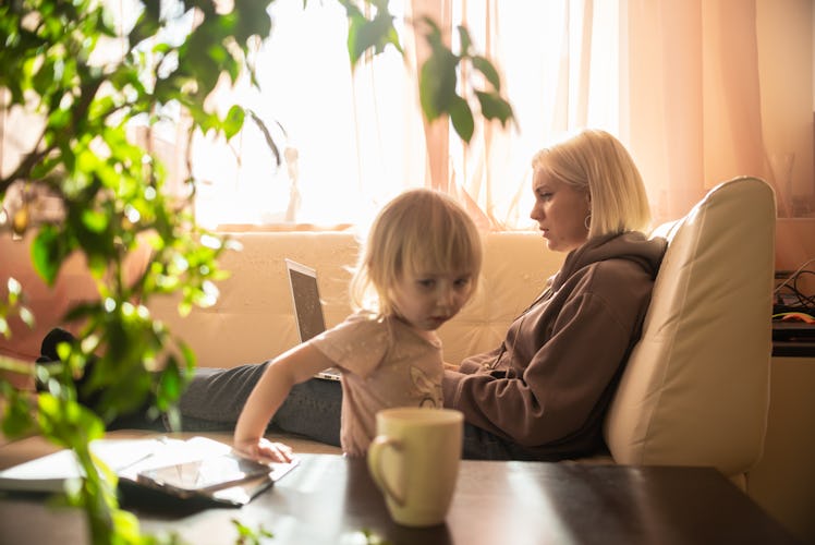 woman businesswoman, freelancer working in home office on computer with child at home.