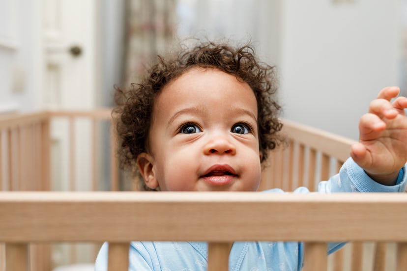 cute toddler in a crib in an article about the 18 month sleep regression