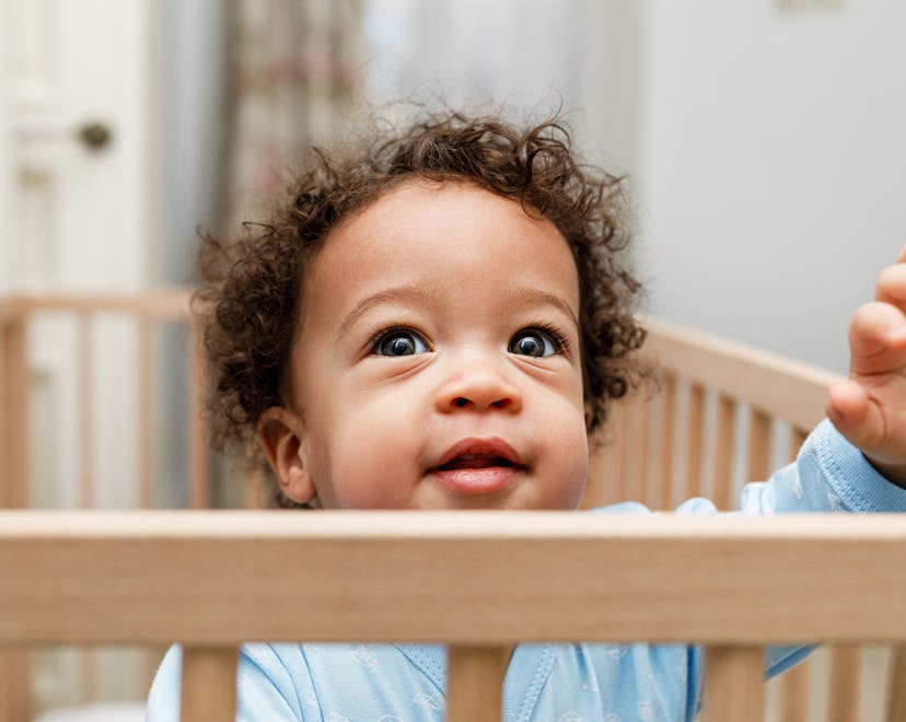 cute toddler in a crib in an article about the 18 month sleep regression