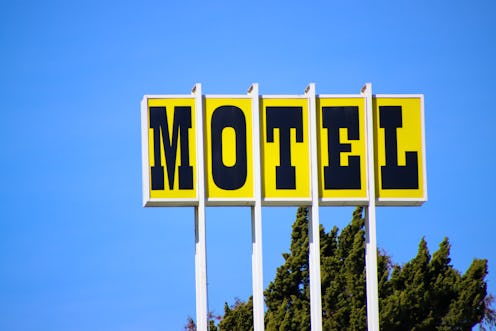 A retro “Motel” sign in black lettering with a yellow background.