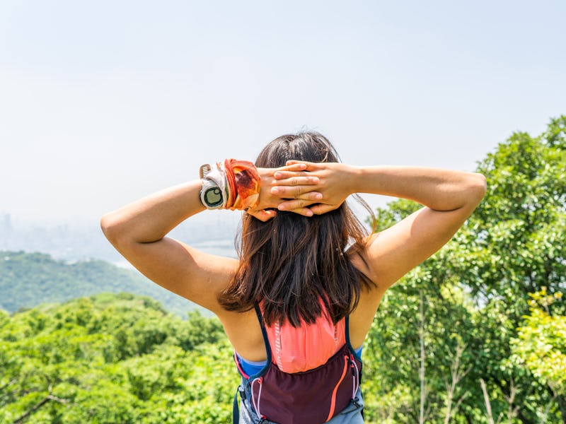 A young runner mountain woman stretching exercise at top of mountain