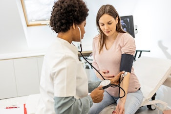 Pregnant woman at the doctor office measuring blood pressure