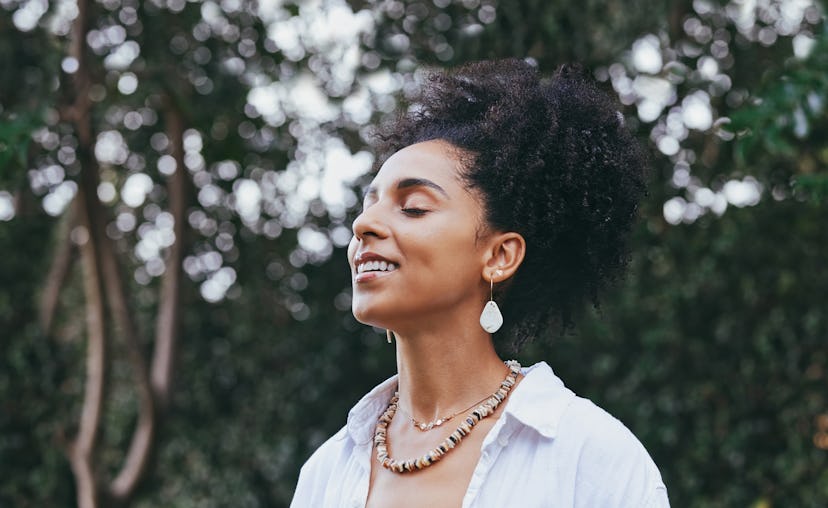 Black woman, breathing and smile for fresh air in nature, travel or calm peace outdoors. Happy Afric...