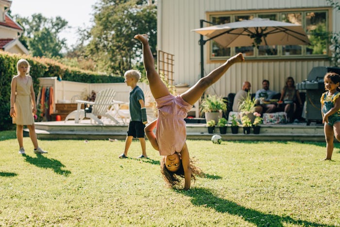 Kids play in the backyard while parents chat together, in a story about the best tips for traveling ...