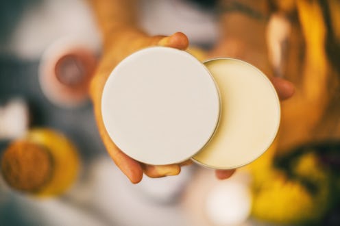 Close up of unrecognizable woman holding an open face sunscreen.