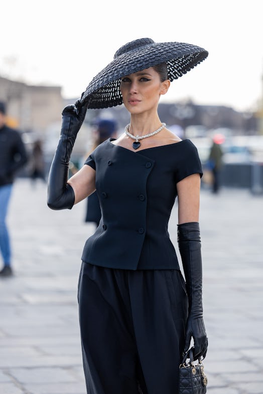 Dramatic hats are a Paris Fashion Week Fall/Winter 2023 street style beauty trend.