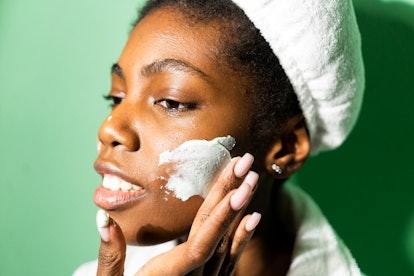 woman applying thick facial moisturizer 