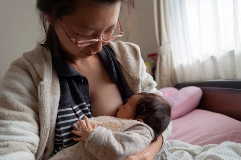 Woman breastfeeds her newborn, in a story about Women's History Month facts.