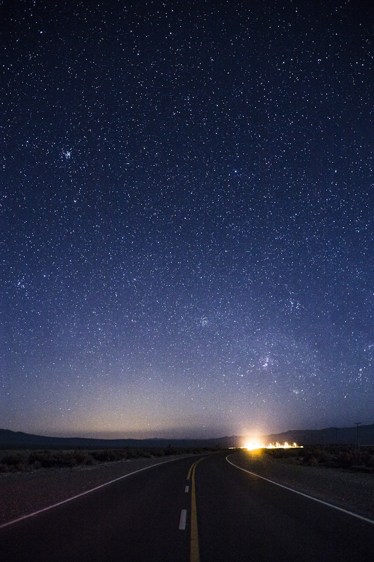 A starry night sky above a highway.