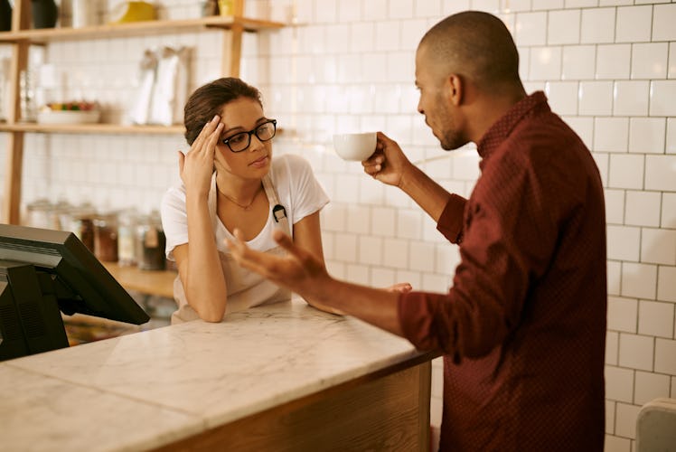 Shot of a young woman serving a difficult customer in a coffee shop