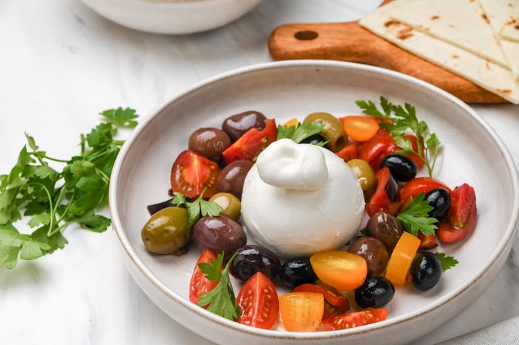 Italian burrata cheese salad with tomatoes, olives and olive oil. healthy diet proteins vegetables