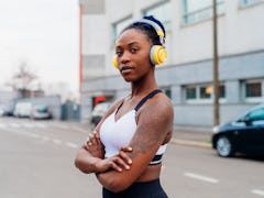 Italy, Milan, Portrait of woman in sports bra and headphones in city