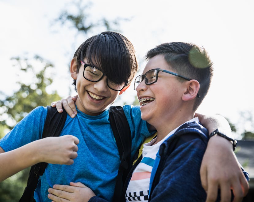 School age brothers laughing outdoors, brother names