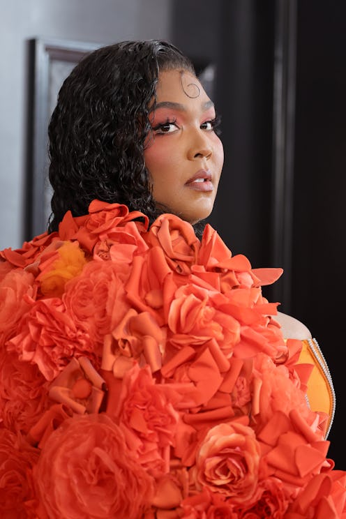 Lizzo attended the 2023 GRAMMY Awards in an organ floral cape with matching orange makeup
