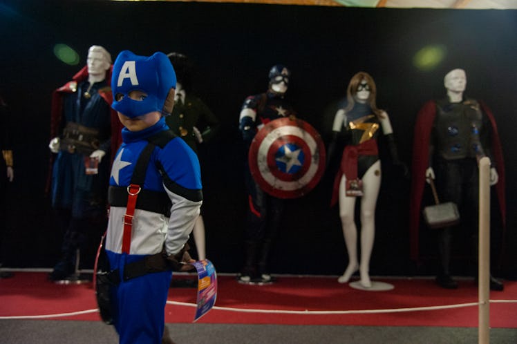 A child poses for a photo in front of a set of the Marvel Avengers costumes during the first day of ...