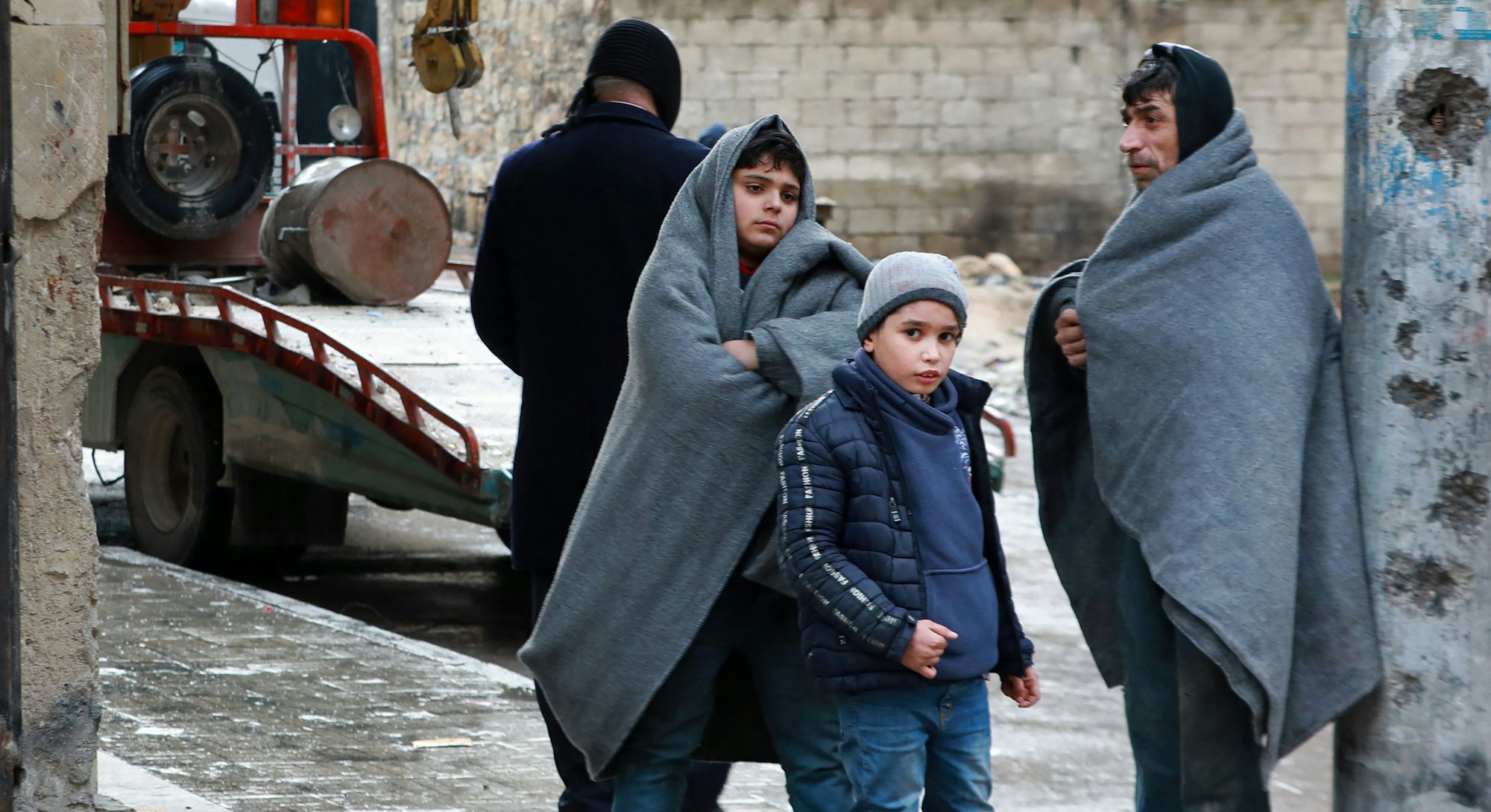 A Syrian man and children gather outside on a street following a deadly earthquake on February 6, 20...