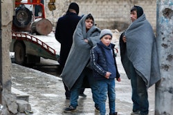 A Syrian man and children gather outside on a street following a deadly earthquake on February 6, 20...