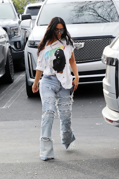 Kim Kardashian wore a distressed pair of jeans and an off-the-shoulder band tee. 