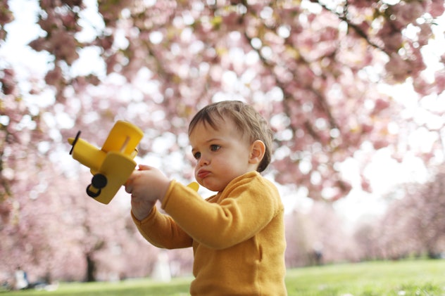 Toddler playing with toy airplane outdoors, in a story about fruit baby names