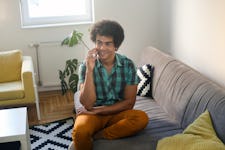 中年男子用手机在家里。大约35岁混血男性。