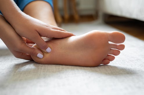 Young woman massaging her foot